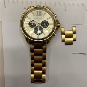 Michael Kors gold watch with white face.